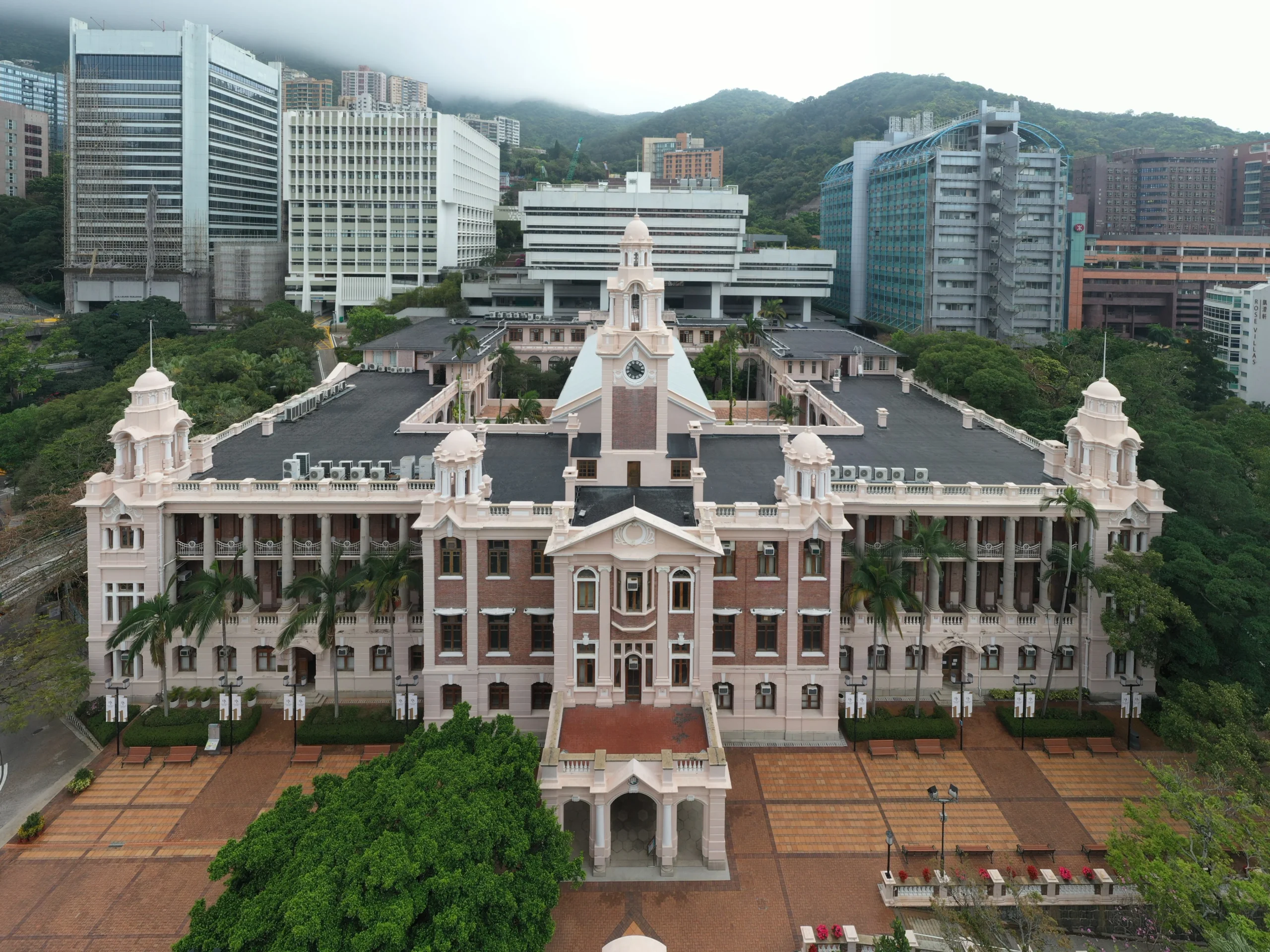 The historic exterior of the University of Hong Kong (HKU) Main Building with its iconic clock tower and red brick architecture. 香港大學本部大樓 (Main Building) 的紅磚建築與鐘樓外觀。 香港大学本部大楼 (Main Building) 的红砖建筑与钟楼外观。