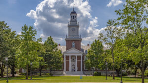 繁體中文 (Traditional Chinese): 美國約翰霍普金斯大學 Johns Hopkins University 標誌性 Gilman Hall 鐘樓校園建築，適合計劃透過 Common App 申請美國 Top 20 頂尖名校、醫學預科或生物科學學位的海外留學生作為選校參考。 簡體中文 (Simplified Chinese): 美国约翰霍普金斯大学 Johns Hopkins University 标志性 Gilman Hall 钟楼校园建筑，适合计划透过 Common App 申请美国 Top 20 顶尖名校、医学预科或生物科学学位的海外留学生作为选校参考。 英文 (English): The iconic Gilman Hall clock tower on the Johns Hopkins University (JHU) Homewood campus in Baltimore, ideal for international students planning their US university admissions strategy for Top 20 institutions.