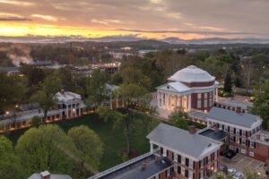 繁體中文 (Traditional Chinese): 美國弗吉尼亞大學 University of Virginia 地標 Rotunda 圓頂建築與校園大草坪黃昏全景，適合計劃透過海外升學、美國公立常春藤名校或 Common App 系統布局美國留學的香港及海外精英學生作為選校參考。 簡體中文 (Simplified Chinese): 美国弗吉尼亚大学 University of Virginia 地标 Rotunda 圆顶建筑与校园大草坪黄昏全景，适合计划透过海外升学、美国公立常春藤名校或 Common App 系统布局美国留学的香港及海外精英学生作为选校参考。 英文 (English): An aerial evening view of The Rotunda and The Lawn at the University of Virginia (UVA) campus, ideal for international students planning their US university admissions strategy for public Ivy League schools.