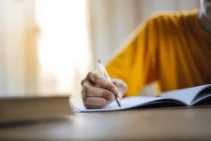 【繁體中文】 學生手拿鋼筆專注撰寫英國 UCAS 個人陳述與美國大學 Common App 申請文書特寫,適合用作留學文書精修與 Personal Statement 寫作教學網誌的主題配圖。 【簡體中文】 学生手拿钢笔专注撰写英国 UCAS 个人陈述与美国大学 Common App 申请文书特写,适合用作留学文书精修与 Personal Statement 写作教学网志的主题配图。 【英文】 A close-up shot of a student holding a pen and writing a Personal Statement or university application essay, perfect for blogs about UCAS personal statement templates and Common App essay editing.